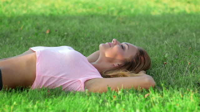 Beautiful athlete resting on the green grass