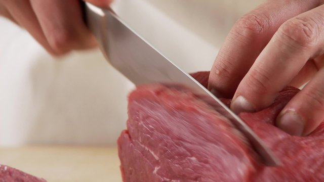 Veal shoulder being being cut into escalopes
