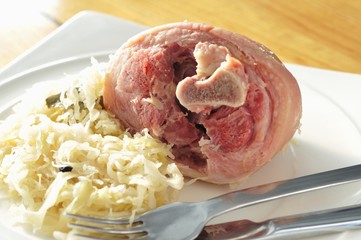 Fototapeta premium Cooked Eisbein (cured knuckle of pork) with sauerkraut