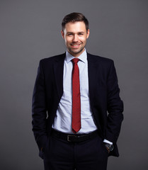 Cool businessman standing on grey background