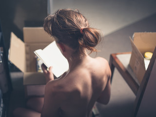Topless woman packing a box - obrazy, fototapety, plakaty
