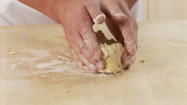 Shortcrust pastry being kneaded and dusted with flour