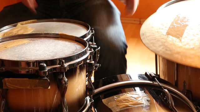 A drummer performing on his Drumset.
