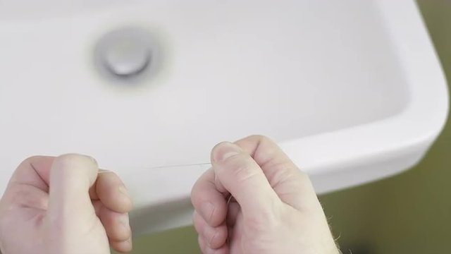 Man wrapping floss around his finger
