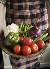 Woman holding tray of assorted vegetables