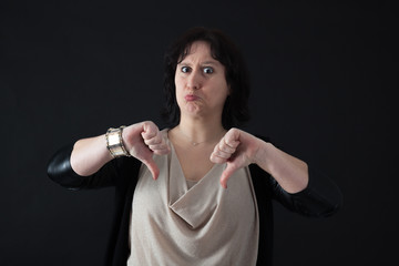 Fototapeta premium Beautiful woman doing different expressions in different sets of clothes: thumbs down