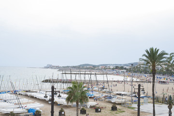 Port next to the beach with a village in the background.