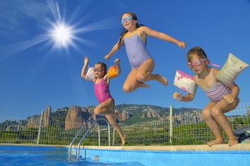 Kids playing in a swimming pool during summer - 89472470