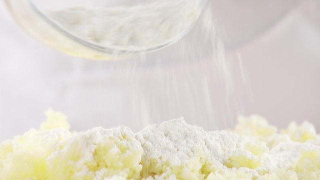 Flour being sprinkled over cooked potatoes