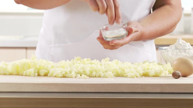 Cooked potatoes being seasoned with salt