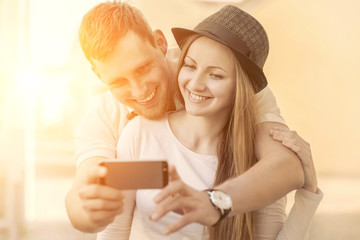 Touristic couple shooting on the modile phone at the city street