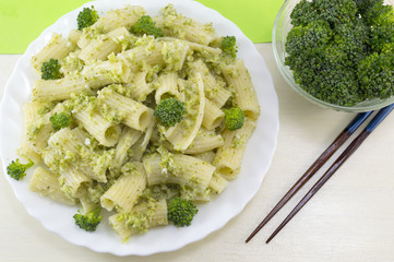 Pasta with broccoli served with cooked broccoli in a white bow o