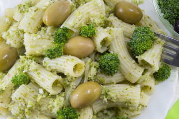 Pasta with broccoli and olives close up