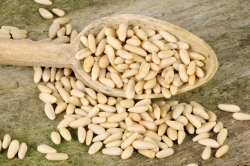 Pine nuts in and beside wooden spoon