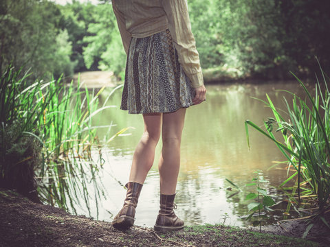 Young woman standing by pond in forest