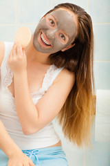 Woman face with mud facial mask