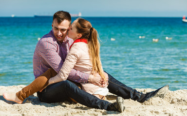 couple sitting on beach relaxing and hugging
