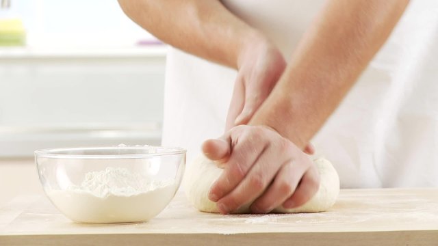Pizza dough being kneaded and placed in a bowl