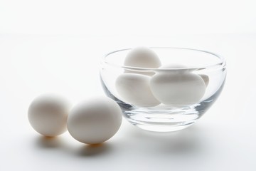 White eggs in and beside a glass bowl