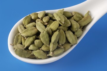 Cardamom pods on a porcelain spoon