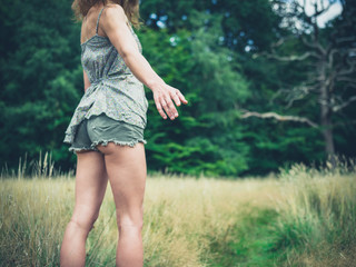 Young woman standing in meadow offering hand
