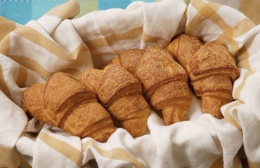 Four croisssants in bread basket