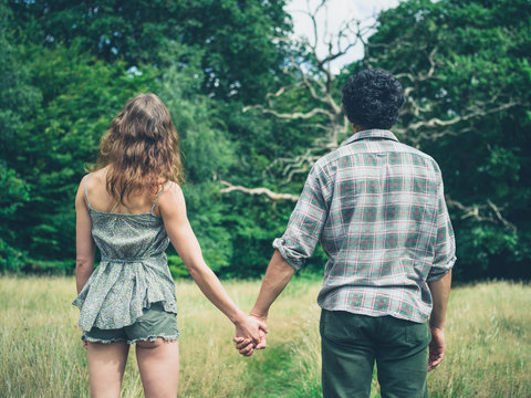 Young couple holding hands in meadow