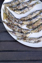 Grilled sardines on white platter