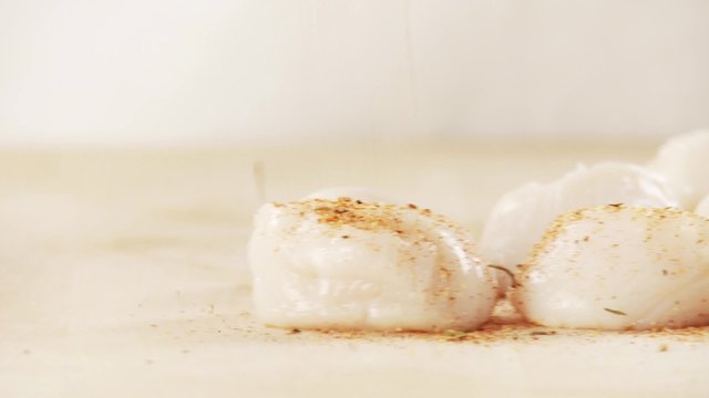 Scallops being seasoned