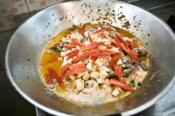 Making green chicken curry with red chillies