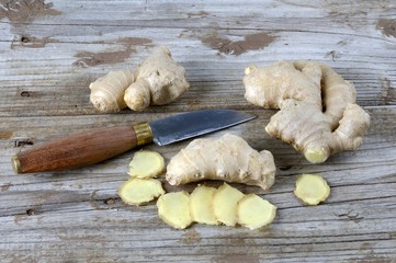Ginger, whole and sliced, beside knife
