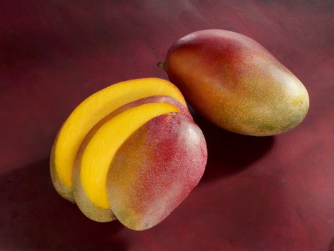 A whole mango and a sliced mango