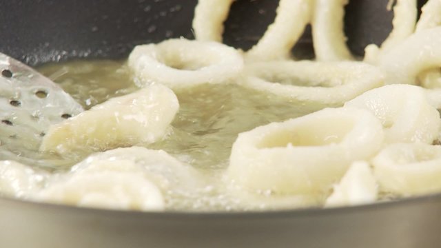 Squid rings being fried in a pan