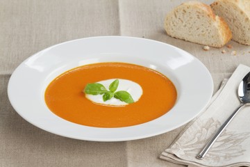 Cream of tomato soup garnished with a dollop of creme fraiche and basil