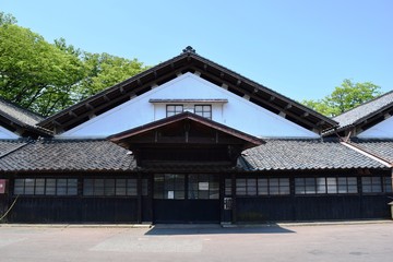山居倉庫（山形県酒田市）／米どころ、山形県庄内のシンボル「山居倉庫」の風景です。山居倉庫は明治26年(1893)に建てられ、現在も現役の米保管倉庫です。白壁、土蔵づくり９棟からなる倉庫の米の収容能力は10,800トン(18万俵)です。夏の高温防止のために背後にケヤキ並木を配し、内部の湿気防止には二重屋根にするなど、自然を利用した先人の知恵が生かされた低温倉庫です。