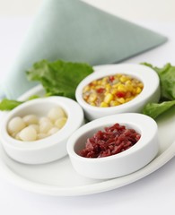 Red Cabbage, Pearl Onions and Corn and Red Peppers in Small White Bowls on a Platter