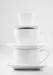 Stacked White Cups and Saucers; Large to Small