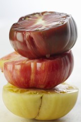 Three Organic Heirloom Tomatoes Stacked; White Background