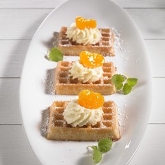 Waffle topped with mandarins and cream