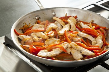 Chicken and Peppers Cooking in a Skillet