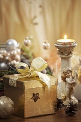 A Christmas present, burning candles and an angel figurine