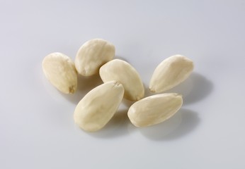 Fototapeta na wymiar Skinned almonds on a white surface
