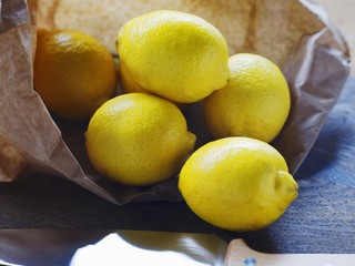 Lemons in a paper bag on a wooden table