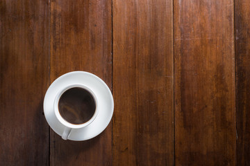 Coffee cup on wooden background, top view