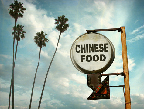 aged and worn vintage photo of chinese food sign and palm trees