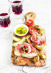 delicious appetizer to wine - toast with ham, olives, tomatoes