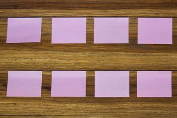 Post-it notes on wooden background.