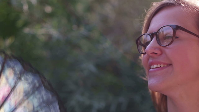 Beautiful woman behind fan, Girl with fan smiling in the nature

