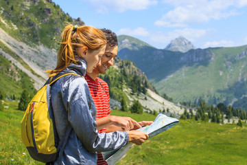 Young beautiful Couple planning the route and looking at the map in the mountains of Montenegro
