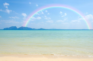 Colorful rainbow over a Tropical beach of Andaman Sea Thailand.